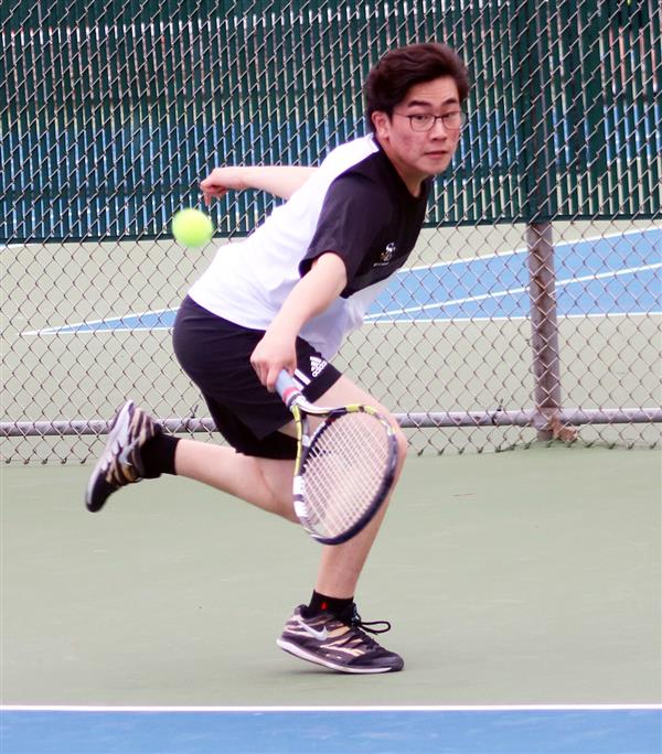  Boys tennis senior Michael Cho returns a volley.
