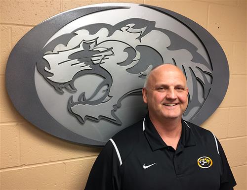 Athletic/Activities Director Rob Davis with tiger logo in background. 