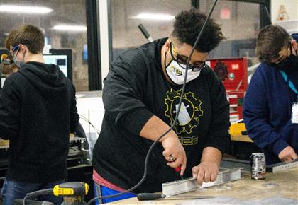 Team SCREAM member works on a robot.